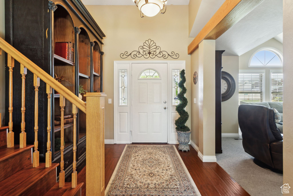 Foyer with stairway, dark wood-style floors, and baseboards