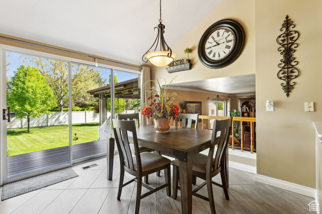 Dining room with baseboards, lofted ceiling, and light tile patterned floors