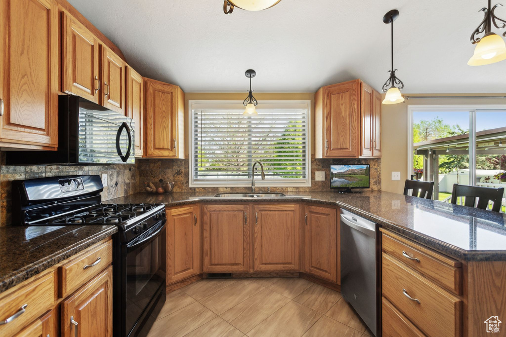 Kitchen featuring black appliances, a sink, healthy amount of natural light, and backsplash