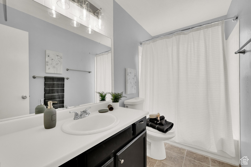 Bathroom with toilet, vanity, and shower / bathtub combination with curtain