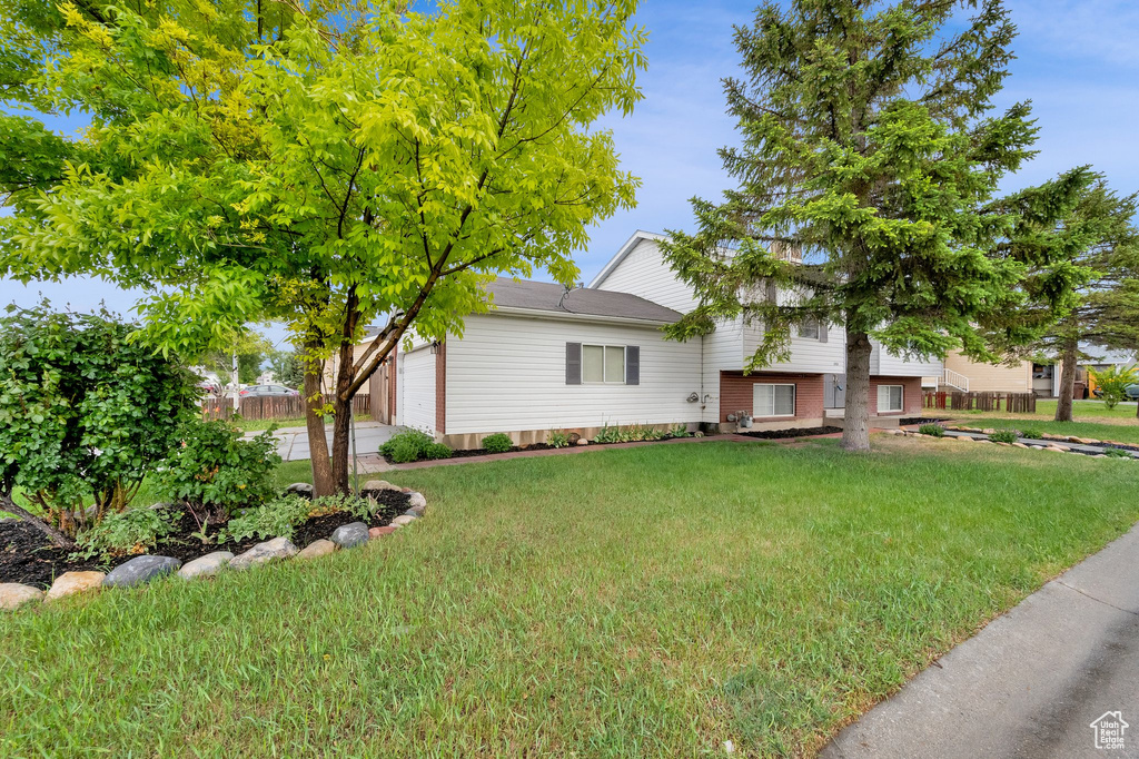 View of front of property featuring a front yard and an attached garage