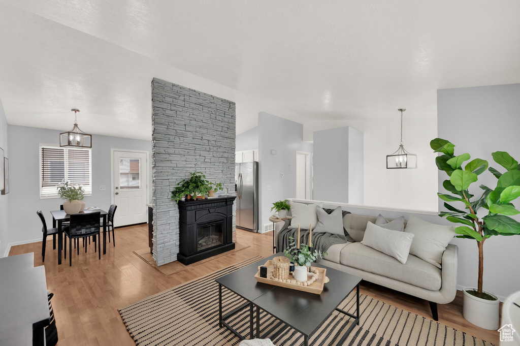 Living room with light wood-type flooring and a glass covered fireplace