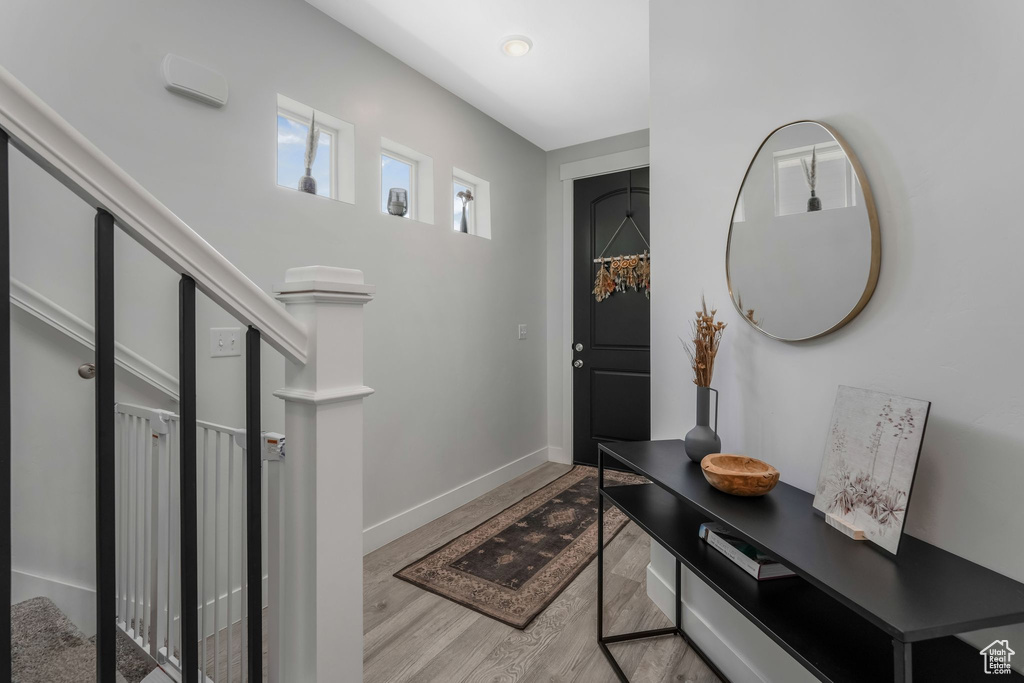 Foyer entrance with wood finished floors and baseboards