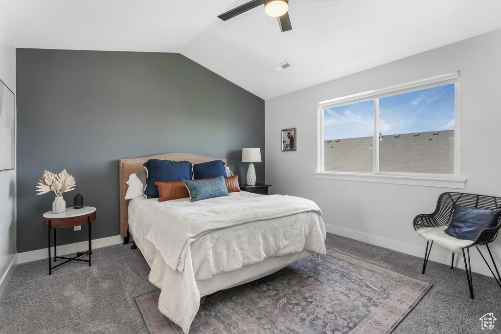 Carpeted bedroom with lofted ceiling, a ceiling fan, and baseboards