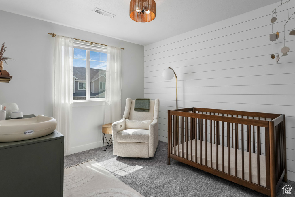 Bedroom with carpet floors, a crib, and baseboards