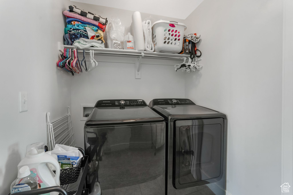 Washroom featuring washing machine and clothes dryer and tile patterned flooring
