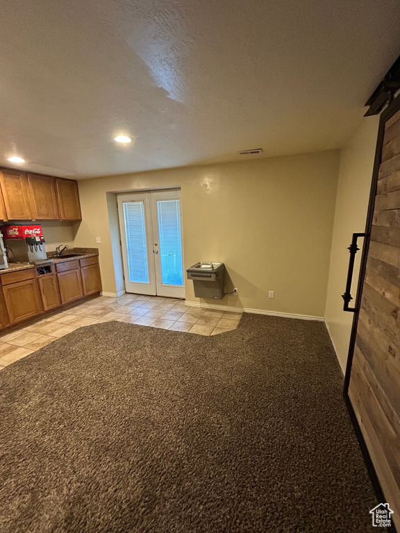Unfurnished living room featuring french doors, recessed lighting, light tile patterned flooring, baseboards, and light colored carpet