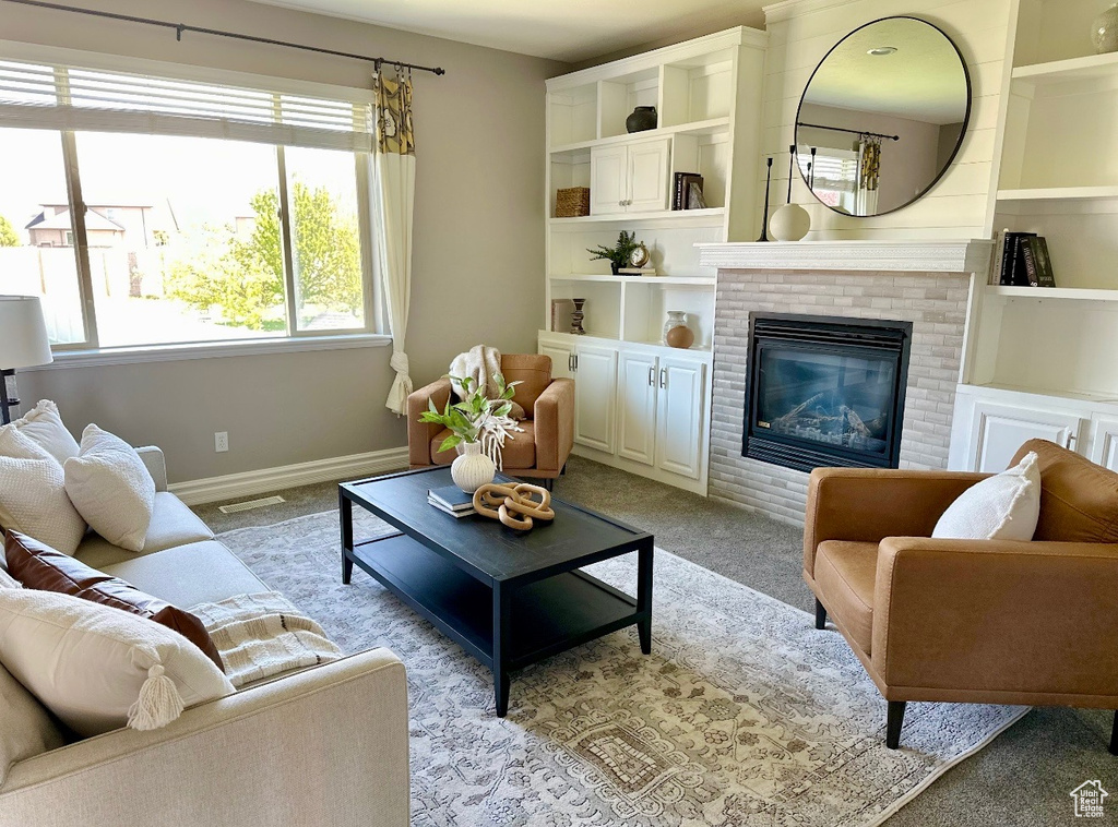 Living room with light carpet, baseboards, and a fireplace