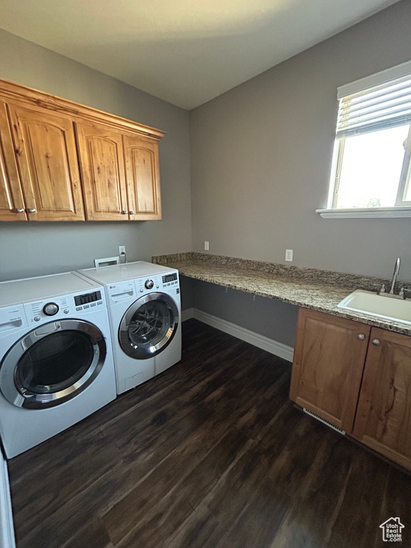Laundry area with cabinet space, dark wood-style flooring, washer and clothes dryer, and baseboards
