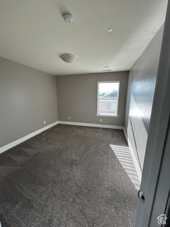 Unfurnished room featuring carpet flooring, baseboards, and a smoke detector
