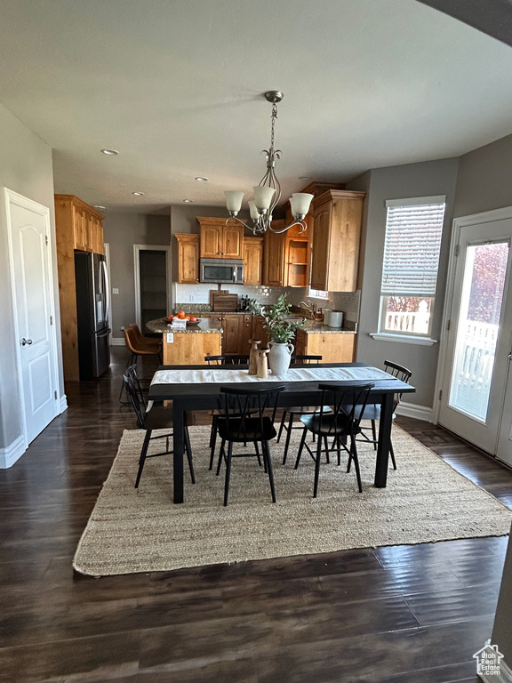 Dining space with a chandelier, baseboards, dark wood-style floors, and recessed lighting