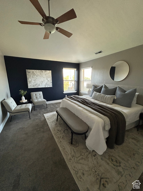 Carpeted bedroom with a ceiling fan, lofted ceiling, and baseboards