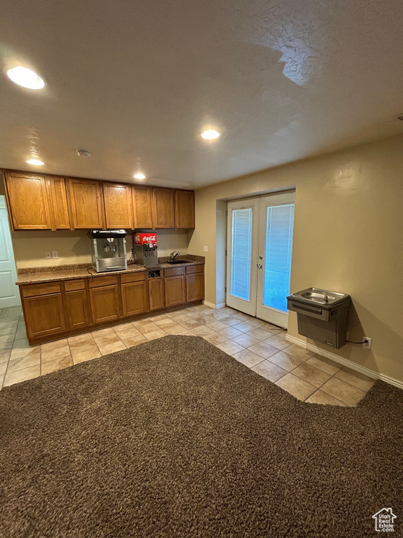 Kitchen featuring light tile patterned floors, french doors, brown cabinetry, recessed lighting, and baseboards