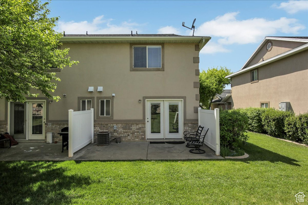 Rear view of property with french doors, a patio, central AC, a lawn, and stucco siding