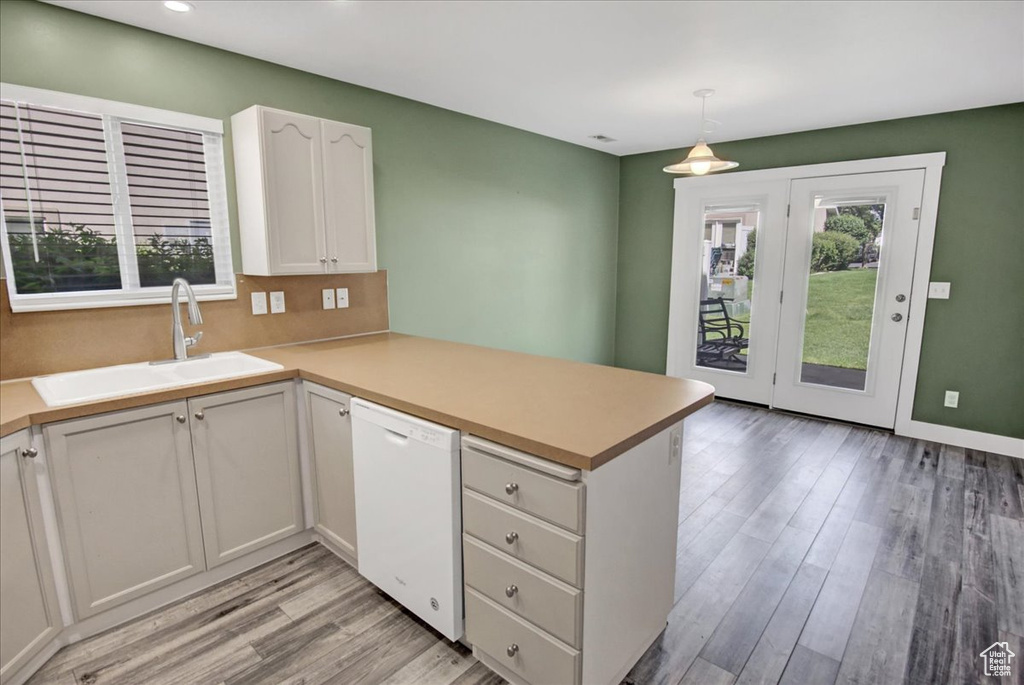 Kitchen featuring dishwasher, a sink, a peninsula, plenty of natural light, and recessed lighting