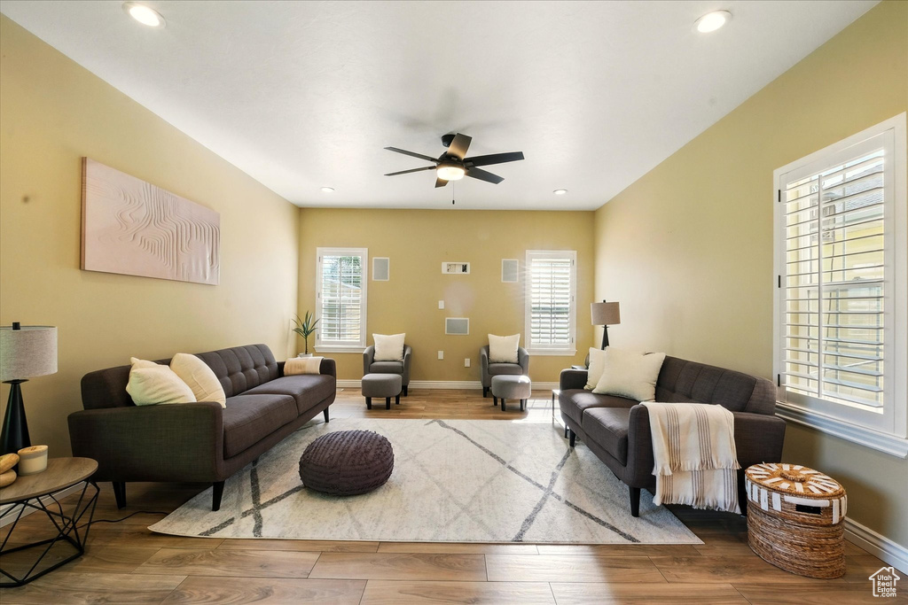 Living area with wood finished floors, a ceiling fan, recessed lighting, and baseboards