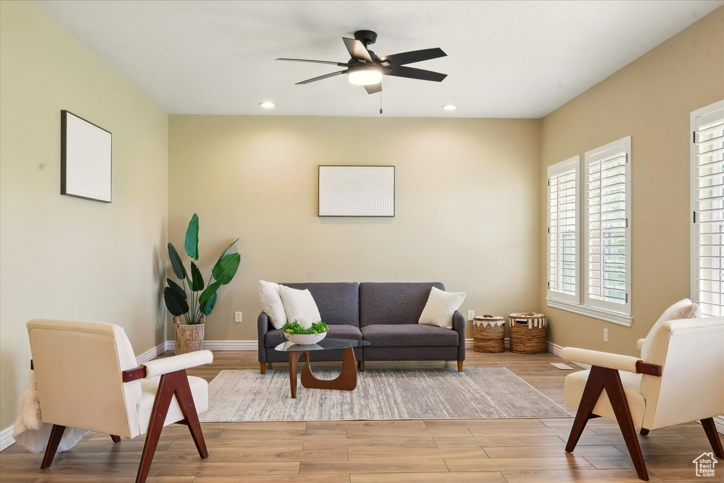 Living area with baseboards, a ceiling fan, light wood-type flooring, and recessed lighting