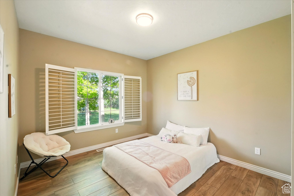 Bedroom featuring wood-type flooring and baseboards