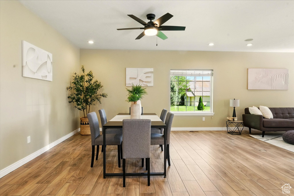 Dining room featuring light wood finished floors, a ceiling fan, recessed lighting, and baseboards