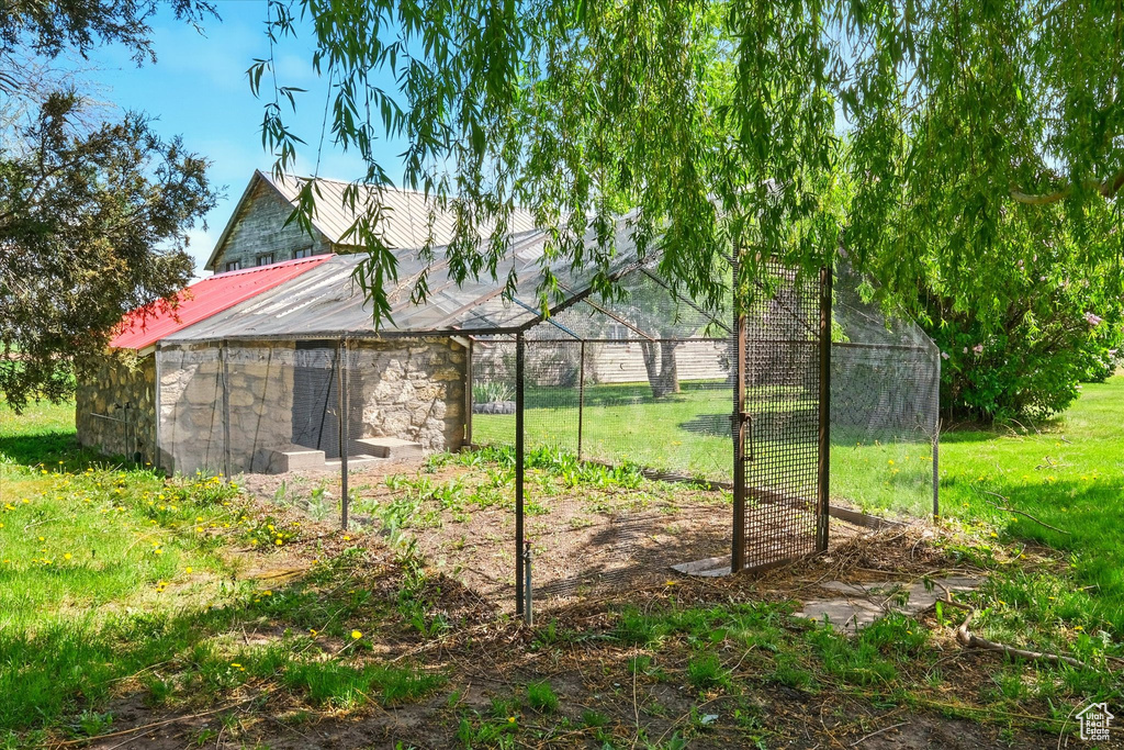 View of green lawn featuring an outbuilding