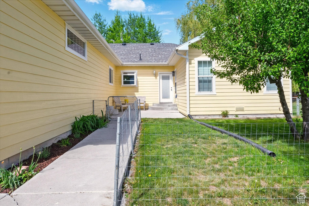 Entrance to property with roof with shingles