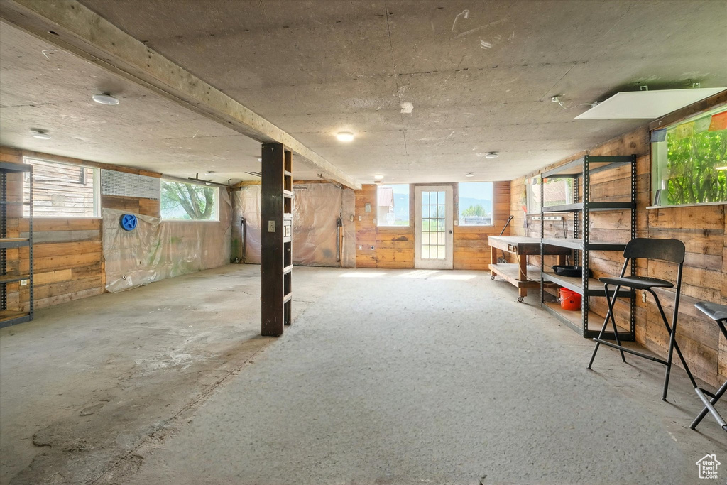 Below grade area featuring wood walls and healthy amount of natural light