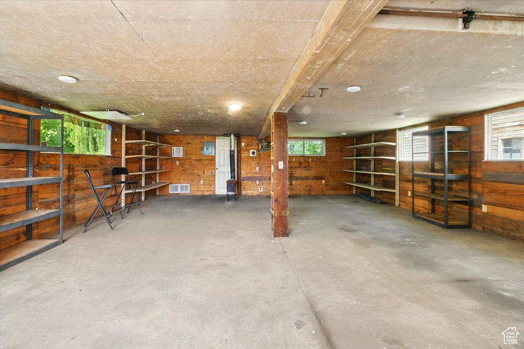 Basement with wood walls and healthy amount of natural light