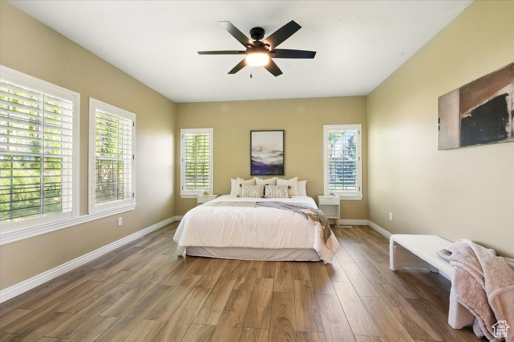 Bedroom featuring wood finished floors, baseboards, and ceiling fan