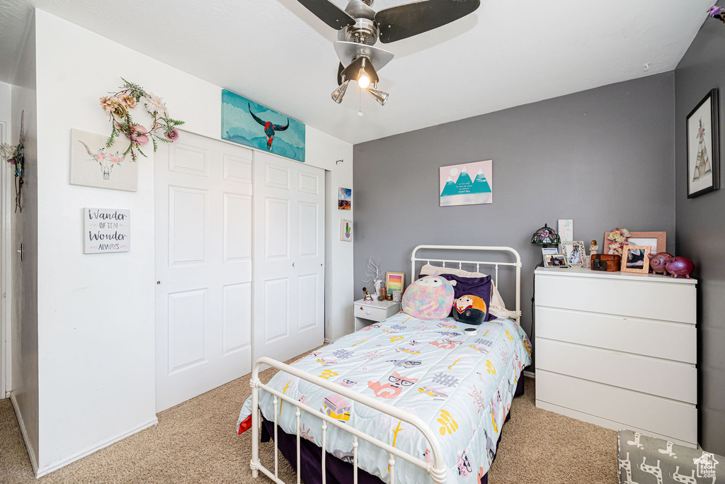 Bedroom with carpet floors, a closet, and a ceiling fan