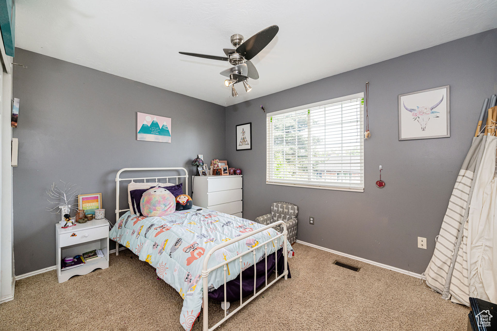 Carpeted bedroom featuring baseboards and a ceiling fan
