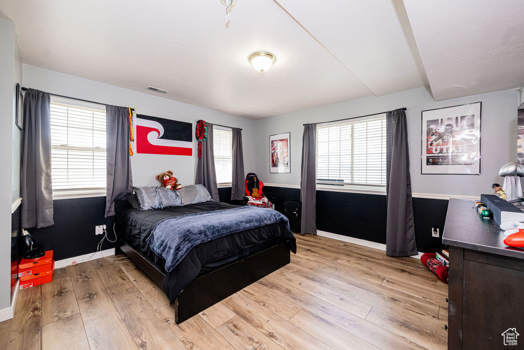 Bedroom with light wood finished floors and baseboards