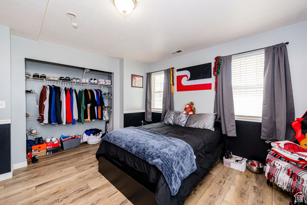 Bedroom featuring wood finished floors and a closet