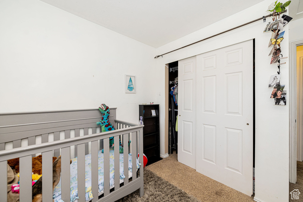 Bedroom with carpet, a closet, and a nursery area