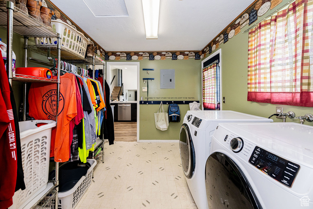 Washroom with washing machine and dryer, electric panel, and tile patterned floors