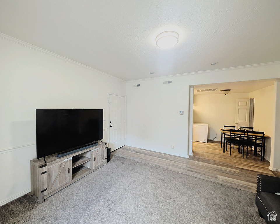 Living room with crown molding, wood finished floors, and baseboards