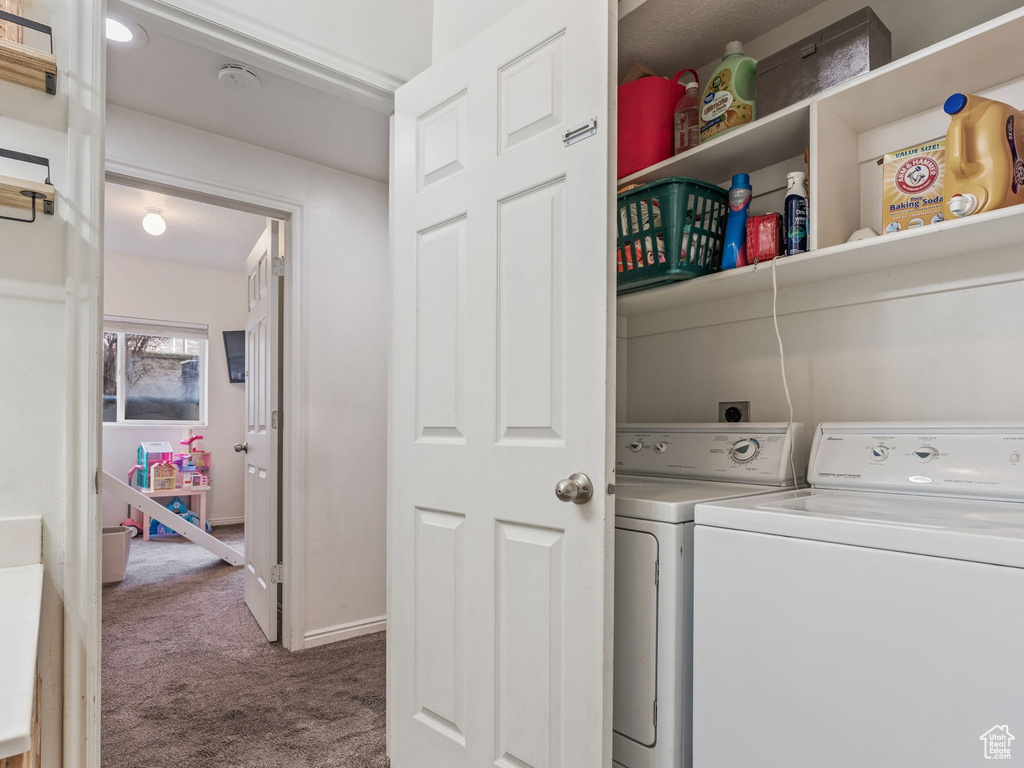 Laundry room featuring washer and dryer and carpet flooring