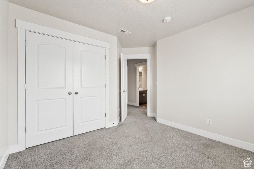Unfurnished bedroom with carpet flooring, baseboards, and a closet