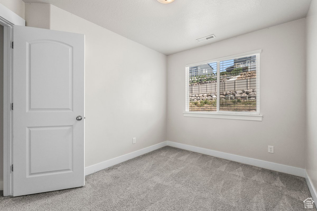 Spare room with carpet and baseboards
