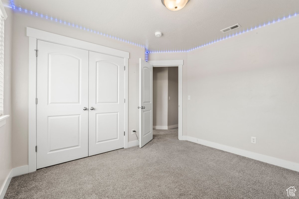 Unfurnished bedroom with carpet floors, baseboards, and a closet