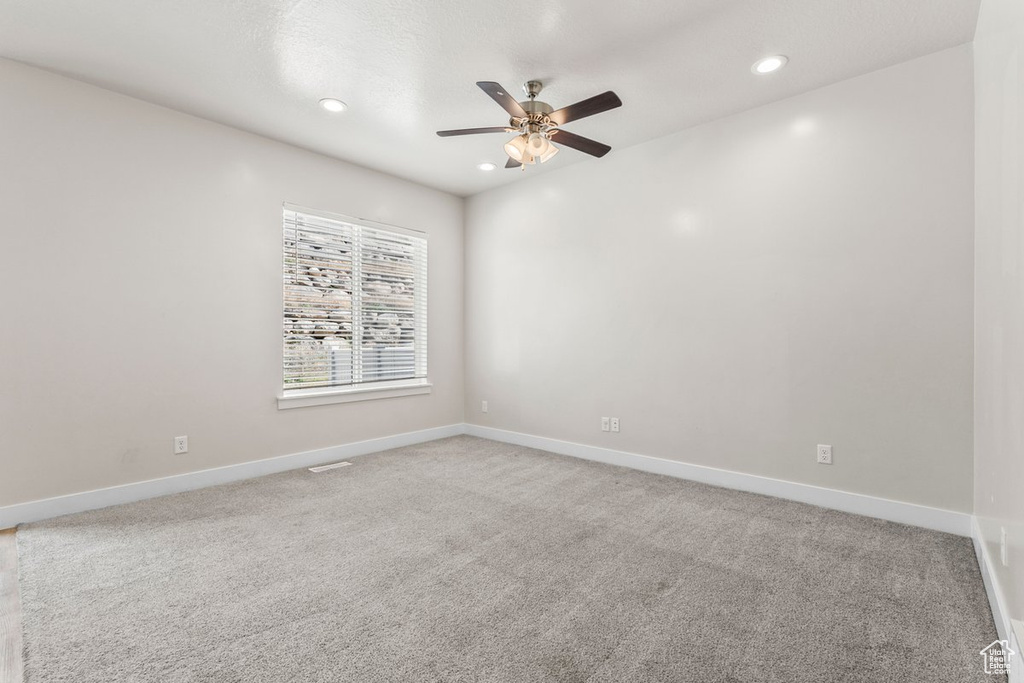 Empty room featuring a ceiling fan, light carpet, recessed lighting, and baseboards