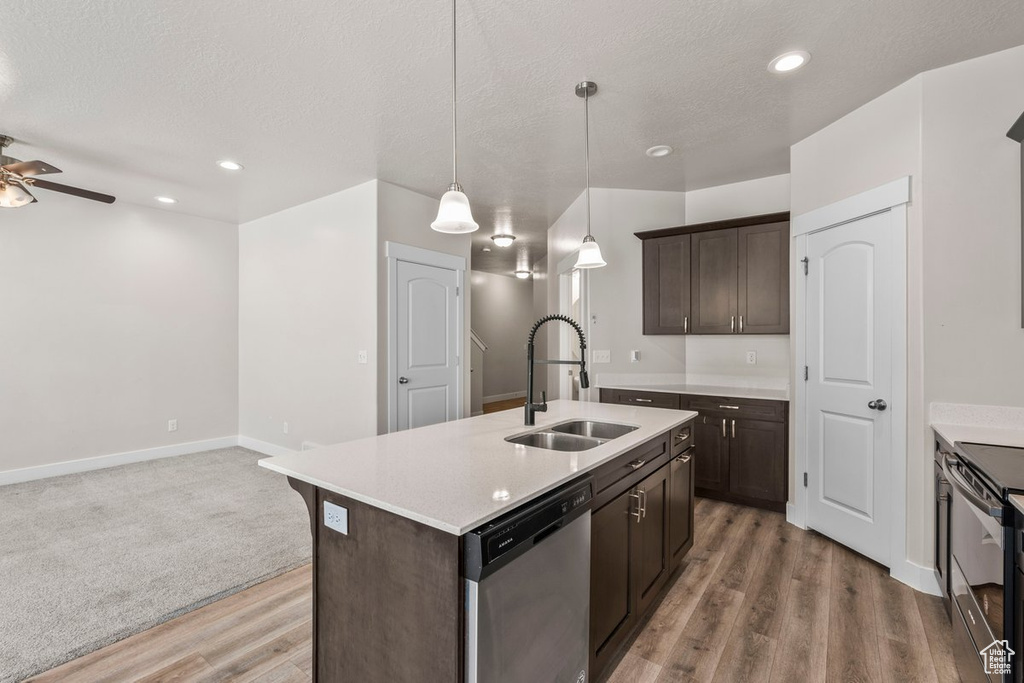 Kitchen with a sink, dishwasher, range with electric cooktop, light wood finished floors, and a ceiling fan