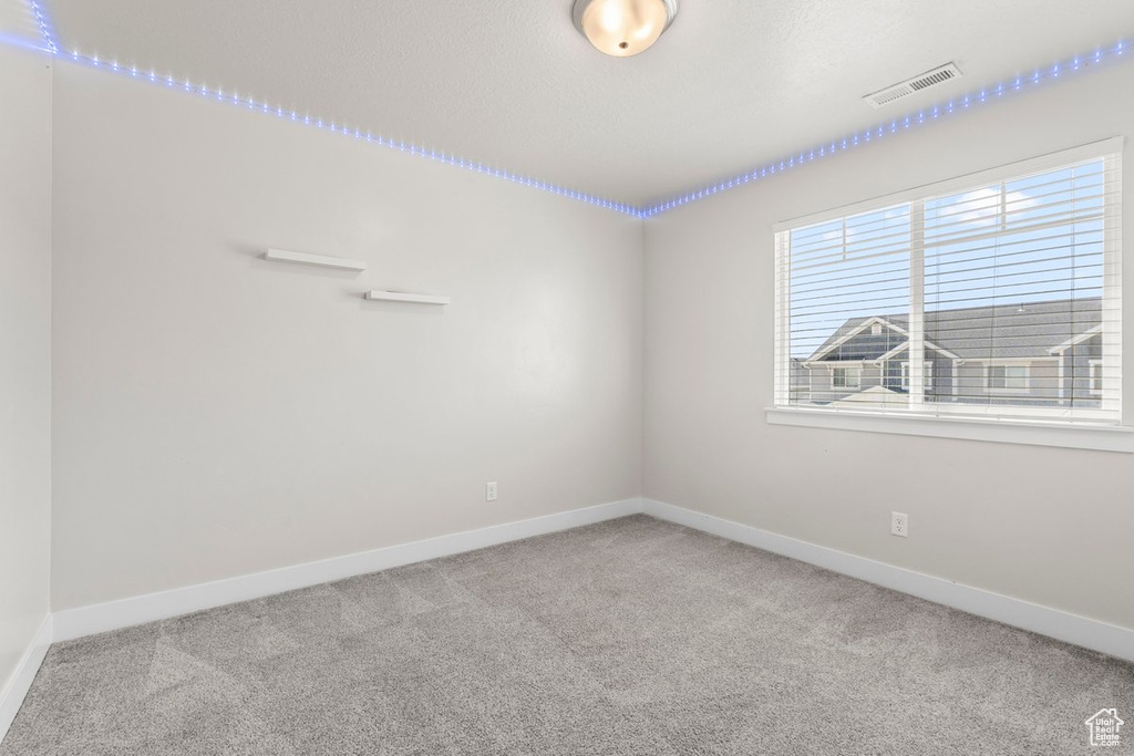 Empty room featuring carpet and baseboards