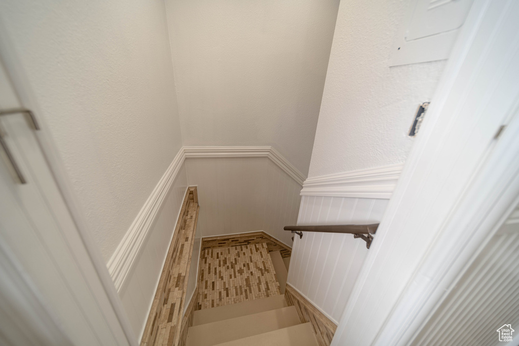 Stairway with a wainscoted wall and a decorative wall