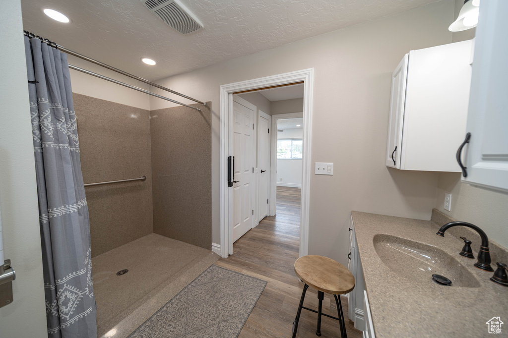 Full bathroom featuring wood finished floors, a shower with shower curtain, recessed lighting, and vanity