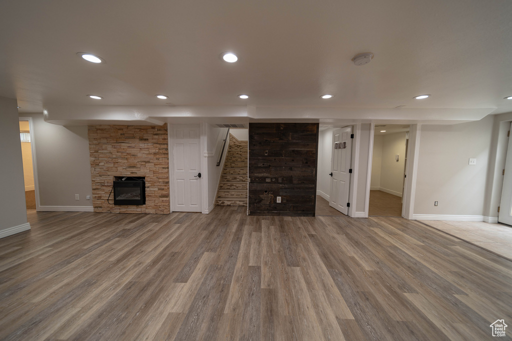 Unfurnished living room with baseboards, wood finished floors, stairs, and recessed lighting