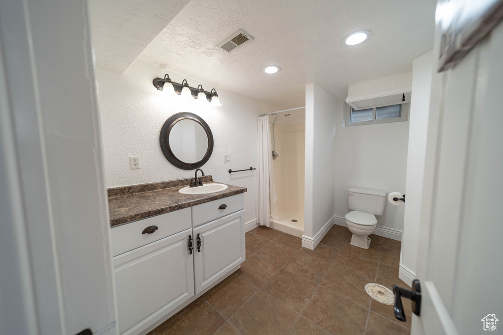 Full bath with toilet, a shower stall, vanity, recessed lighting, and tile patterned floors