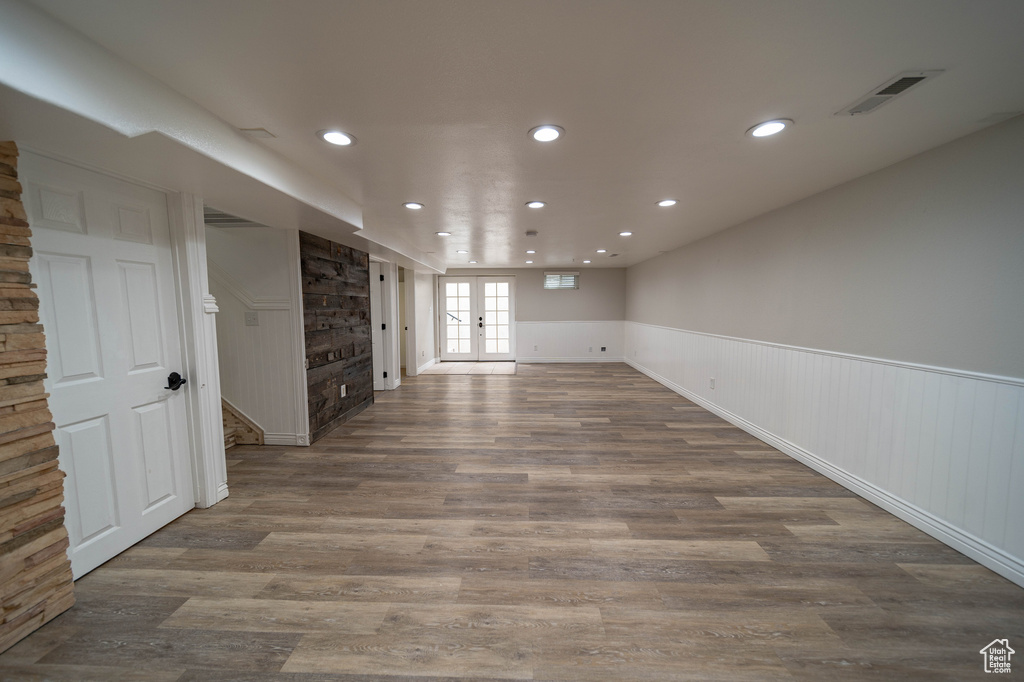 Spare room with wood finished floors, a wainscoted wall, recessed lighting, and french doors
