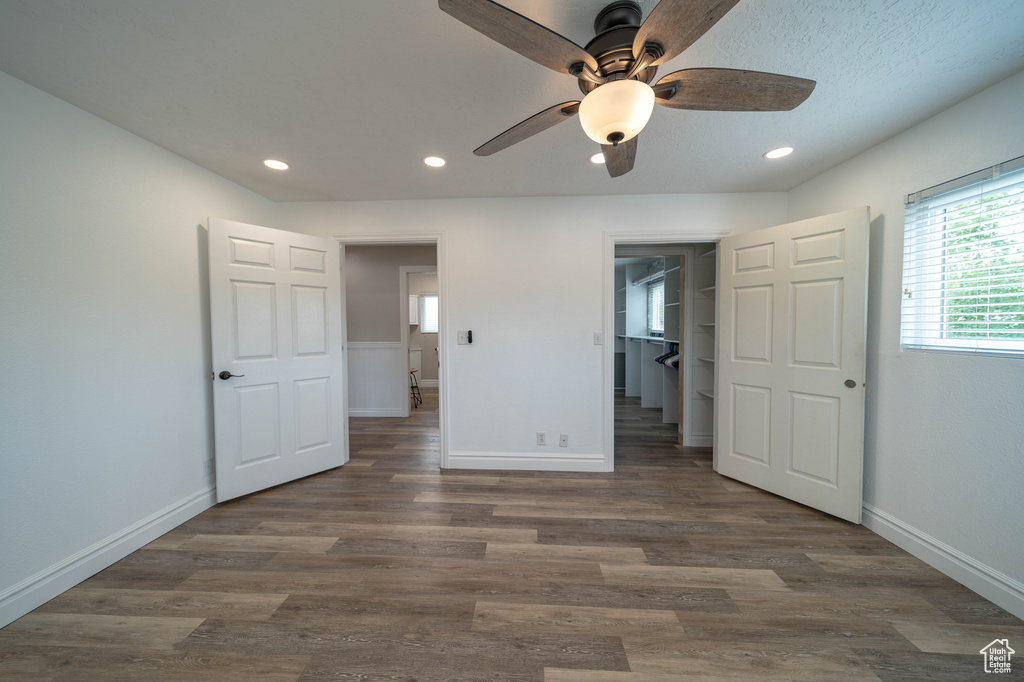 Unfurnished bedroom featuring baseboards, dark wood finished floors, recessed lighting, a spacious closet, and ceiling fan