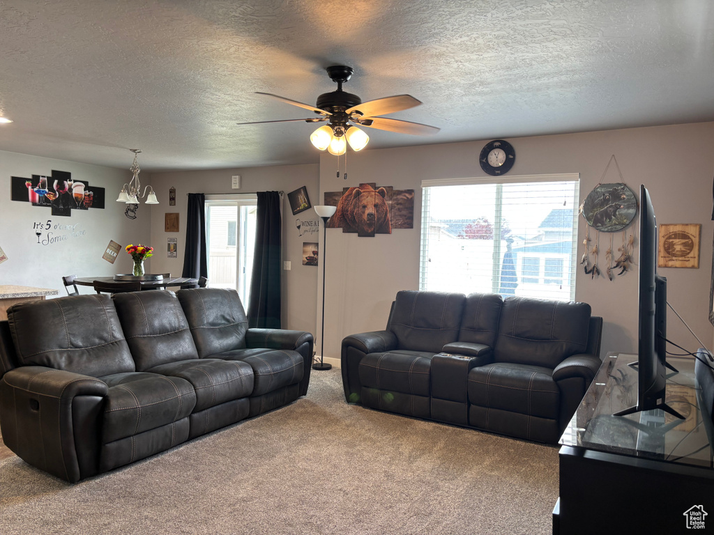 Carpeted living area with a textured ceiling and a ceiling fan