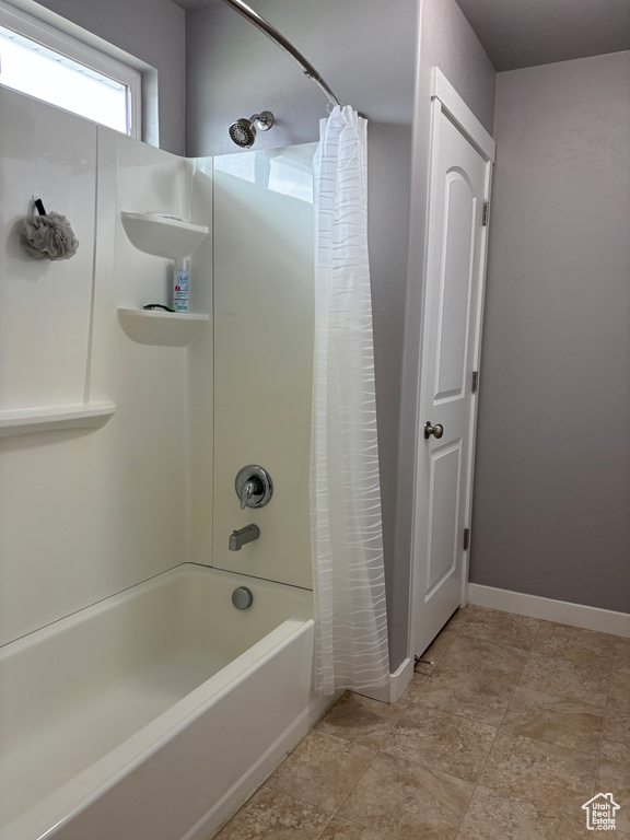Bathroom with shower / tub combo with curtain and baseboards
